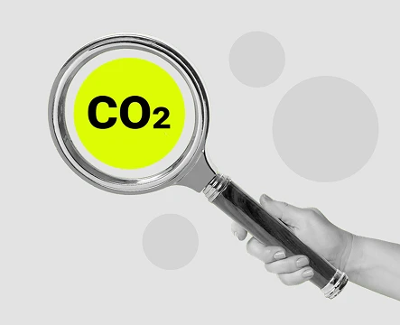 Hand hält ein Smartphone mit Diagramm und CO₂-Symbol, Darstellung von Emissionsdaten und Analyse