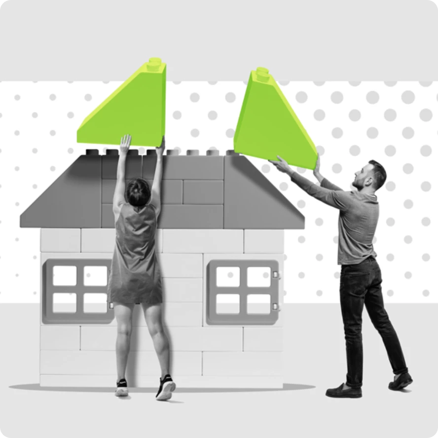 Zwei Menschen bauen ein Haus, indem sie Teile zusammenfügen, was die Zusammenarbeit symbolisiert